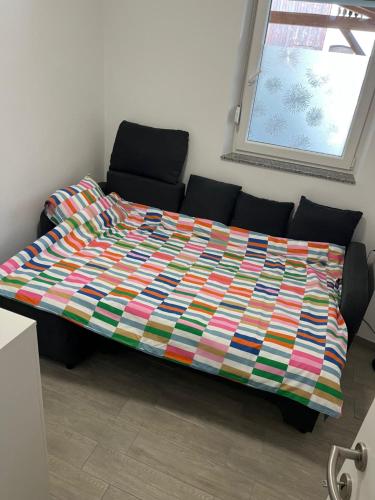 a bed with a colorful blanket on top of it at Apartma GoDeTi in Rečica ob Savinji