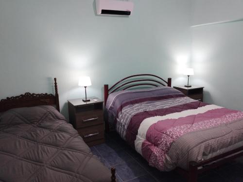 a bedroom with two beds and two lamps on tables at Departamento El Inca 2 in Fiambala
