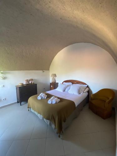 une chambre avec un lit et une chaise dans l'établissement Location de charme au coeur de la Corse - Piscine privative - calme - nature, à San-Lorenzo