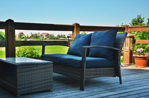 a wicker chair with a blue cushion on a deck at Ostoja Wigierski in Mikolajewo