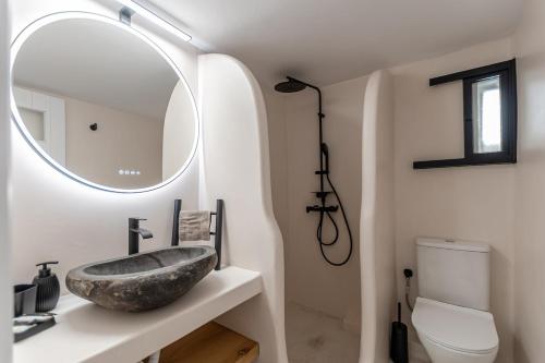 a bathroom with a stone sink and a mirror at Etemis Home Naxos Down Town in Naxos Chora