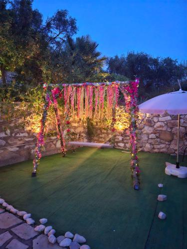 a garden with an arch with flowers and an umbrella at Alegria studios in Gaios