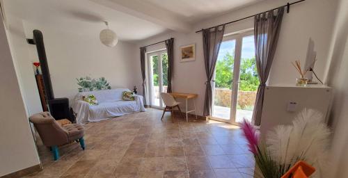 een woonkamer met een bed en een glazen deur bij Villa AveKalu in Opric