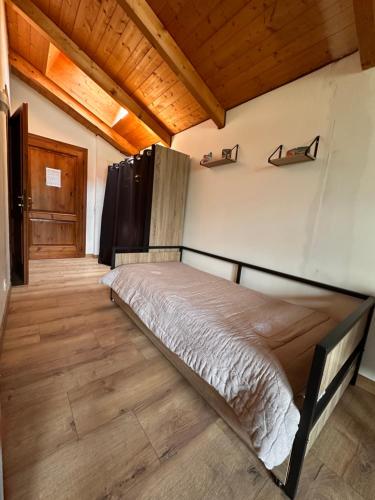 une chambre avec un lit dans une pièce avec des plafonds en bois dans l'établissement OLCA Les Houches, aux Houches