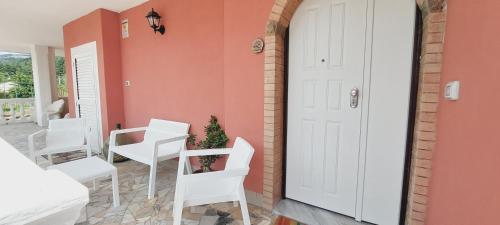 a room with white chairs and a door at Casa Greta La Dimora delle Fate in Villaggio Laceno