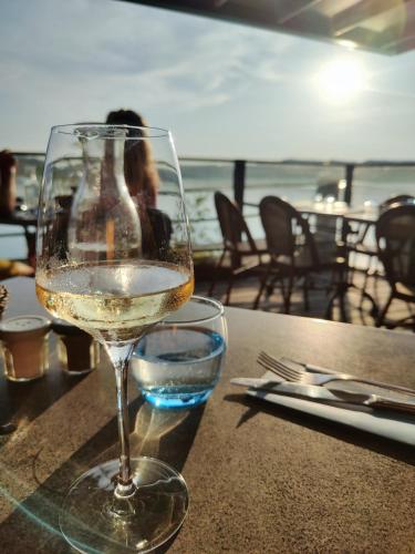 un verre de vin blanc assis sur une table dans l'établissement Beau séjour Aiguebelette, à Aiguebelette-le-Lac