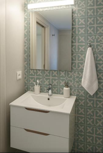 Un baño con un lavabo blanco y un espejo. en Thalassa loft in Tolo, en Tolo