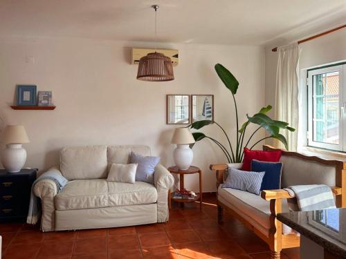 a living room with a couch and a chair at Lagoa azul guest house in Vila Nova de Milfontes