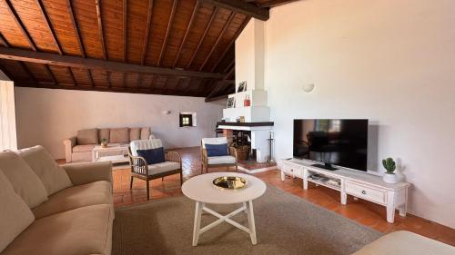 a living room with a couch and a tv at RIVERSIDE RANCH by Nature Bliss in Vila Nova de Milfontes
