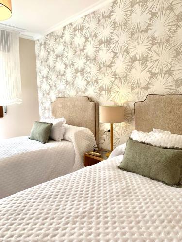 a hotel room with two beds and a patterned wall at Betalia II in Caldas de Reis