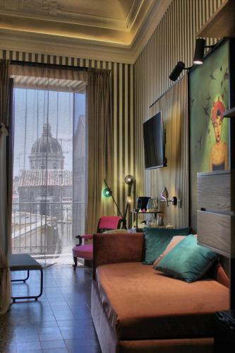 a living room with a couch and a large window at Roby's Boutique Rooms - Luxury B&B in Catania