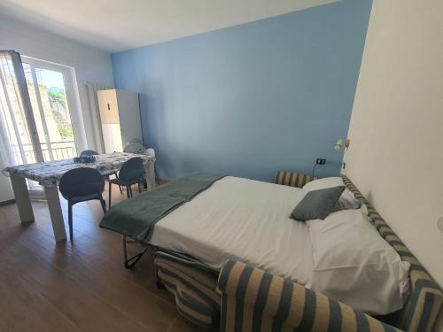 Un dormitorio con una cama y una mesa con sillas. en Kamira's Home, en San Remo