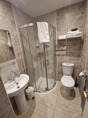 a bathroom with a shower and a toilet and a sink at Twenty Seven in Stornoway