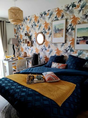 une chambre avec un lit avec une couette bleue dans l'établissement Votre joli studio cosy à Meriadec, à Pluneret