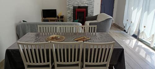 a table with three chairs and a table and a couch at Ty case péi in Saint-Aignan