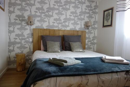 une chambre avec un lit avec deux serviettes dessus dans l'établissement Le Nourhoët havre de Paix à l'Orée de Brocéliande, à Campénéac