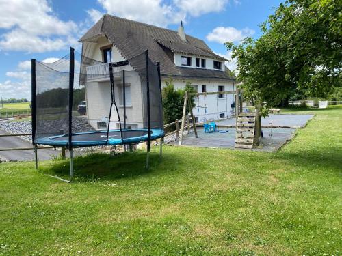 a swing set in a yard in front of a house at La maison normande in Rots