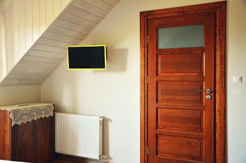 a room with a door and a tv on the wall at Ostoja Wigierski in Mikolajewo