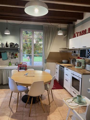 une cuisine avec une table et des chaises dans une cuisine dans l'établissement Charmant gîte 4 étoiles bucolique et calme, à Chouzy-sur-Cisse