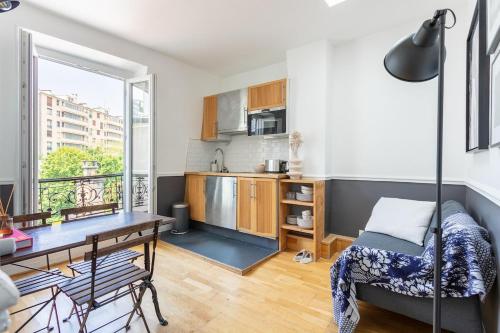 Ce petit appartement comprend une cuisine et une table à manger. dans l'établissement Appartement Trocadéro - Tour Eiffel, à Paris