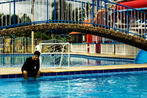 a man sitting in the water in a swimming pool at HCR Hotel y Centro de Convenciones Chinauta Real in Fusagasuga