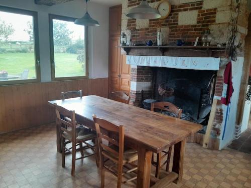 une salle à manger avec une table en bois et une cheminée dans l'établissement Chambre Le Pressoir Saint Christophe, à La Celle-sous-Gouzon