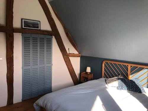 une chambre avec un lit avec une tête de lit en bois dans l'établissement Chambre Le Pressoir Saint Christophe, à La Celle-sous-Gouzon