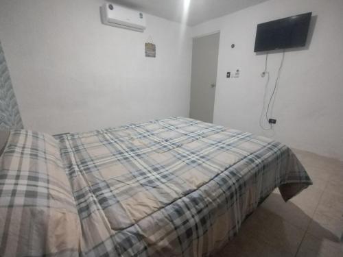 a bedroom with a bed with a plaid blanket at Casa 644 in Mérida