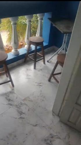 a room with two chairs and a table and a window at Residencial Santos in Nova Viçosa