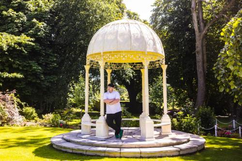 a man standing in a gazebo in a park at Plas Dinas Country House in Caernarfon