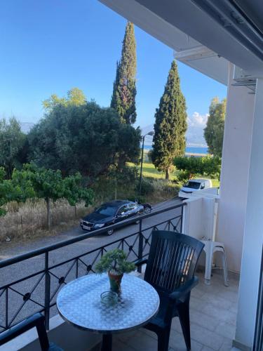 a balcony with a table and a car on the road at Nafpaktio home in Nafpaktos