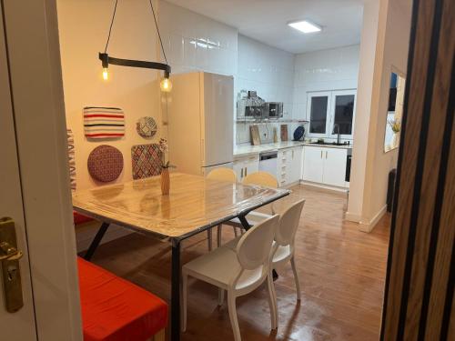 una cucina e una sala da pranzo con tavolo e sedie di Dúplex Horta de Carlota a O Grove