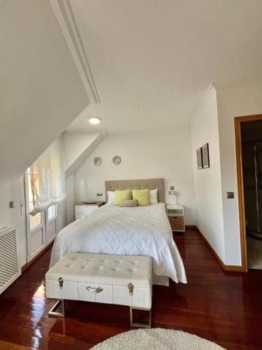 a bedroom with a large bed with a white bedspread at Ático las Palmeras in Caldas de Reis