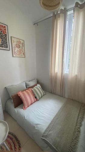 un lit avec deux oreillers dessus dans une chambre dans l'établissement Cocon Paisible a Ivry, à Ivry-sur-Seine