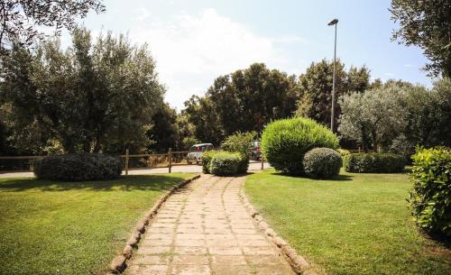 a brick path through a park with bushes and trees at Capalbio Relax - Super terrazza in Capalbio