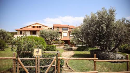a house with a fence in front of a yard at Capalbio Relax - Super terrazza in Capalbio