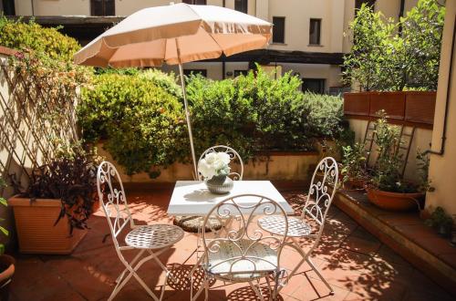 a table and chairs with an umbrella on a patio at Capalbio Relax - Super terrazza in Capalbio