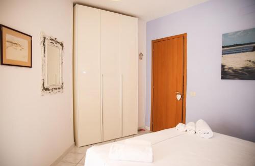 a bedroom with a white bed and a closet at Capalbio Relax - Super terrazza in Capalbio