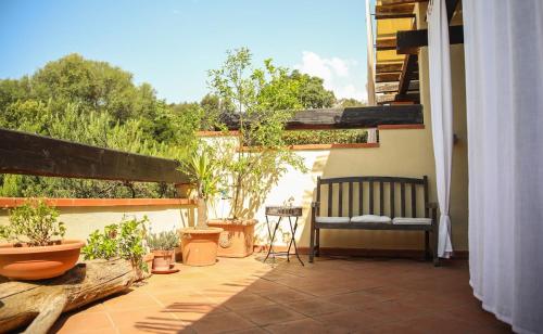 a balcony with a bench and potted plants on it at Capalbio Relax - Super terrazza in Capalbio