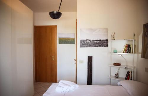 a bedroom with a bed and a wooden door at Capalbio Relax - Super terrazza in Capalbio