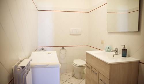 a white bathroom with a toilet and a sink at Capalbio Relax - Super terrazza in Capalbio