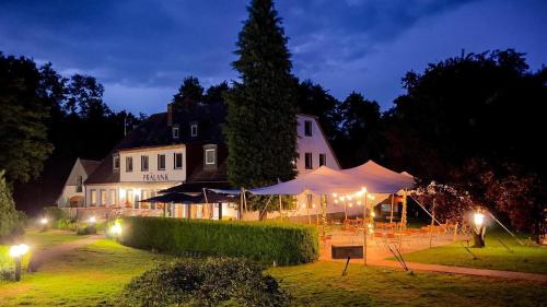 a building with a tent in a yard at night at Landhotel Cafe Prälank in Neustrelitz