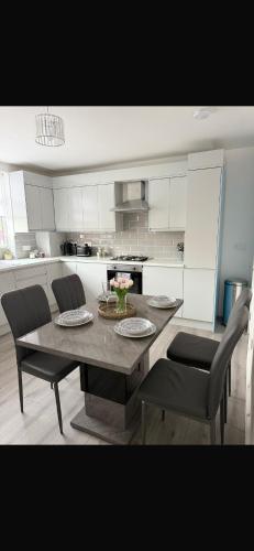 a kitchen with a table and chairs in a kitchen at Home in Leeds in Beeston