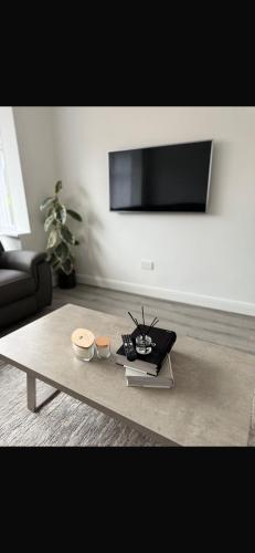 a living room with a coffee table and a tv at Home in Leeds in Beeston