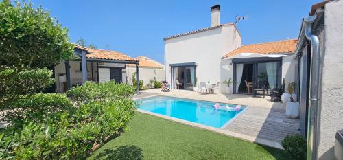 une cour arrière avec une piscine et une maison dans l'établissement Villa Idéalement placée, à La Flotte