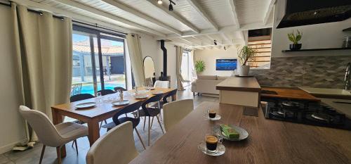 une cuisine et une salle à manger avec une table et des chaises dans l'établissement Villa Idéalement placée, à La Flotte