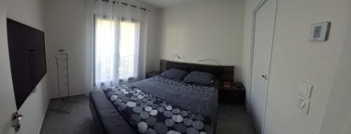 une chambre avec un lit avec des oreillers bleus et une fenêtre dans l'établissement Villa Piscine-Jacuzzi, à Villeneuve-Loubet