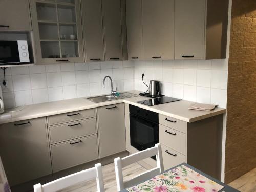 a small kitchen with a sink and a stove at Apartament JANA PAWŁA in Włodawa