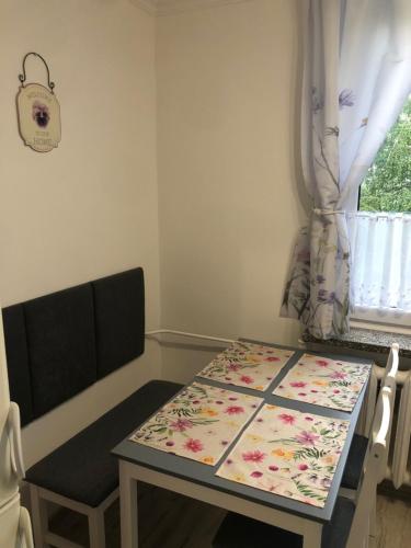 a table and a chair in a room with a window at Apartament JANA PAWŁA in Włodawa