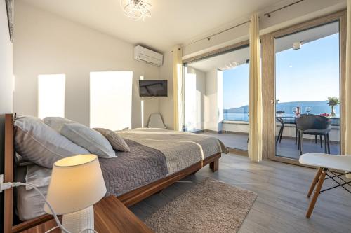 a bedroom with a bed with a view of the ocean at Villa Mandarin Paradise with sea view in Pinezici